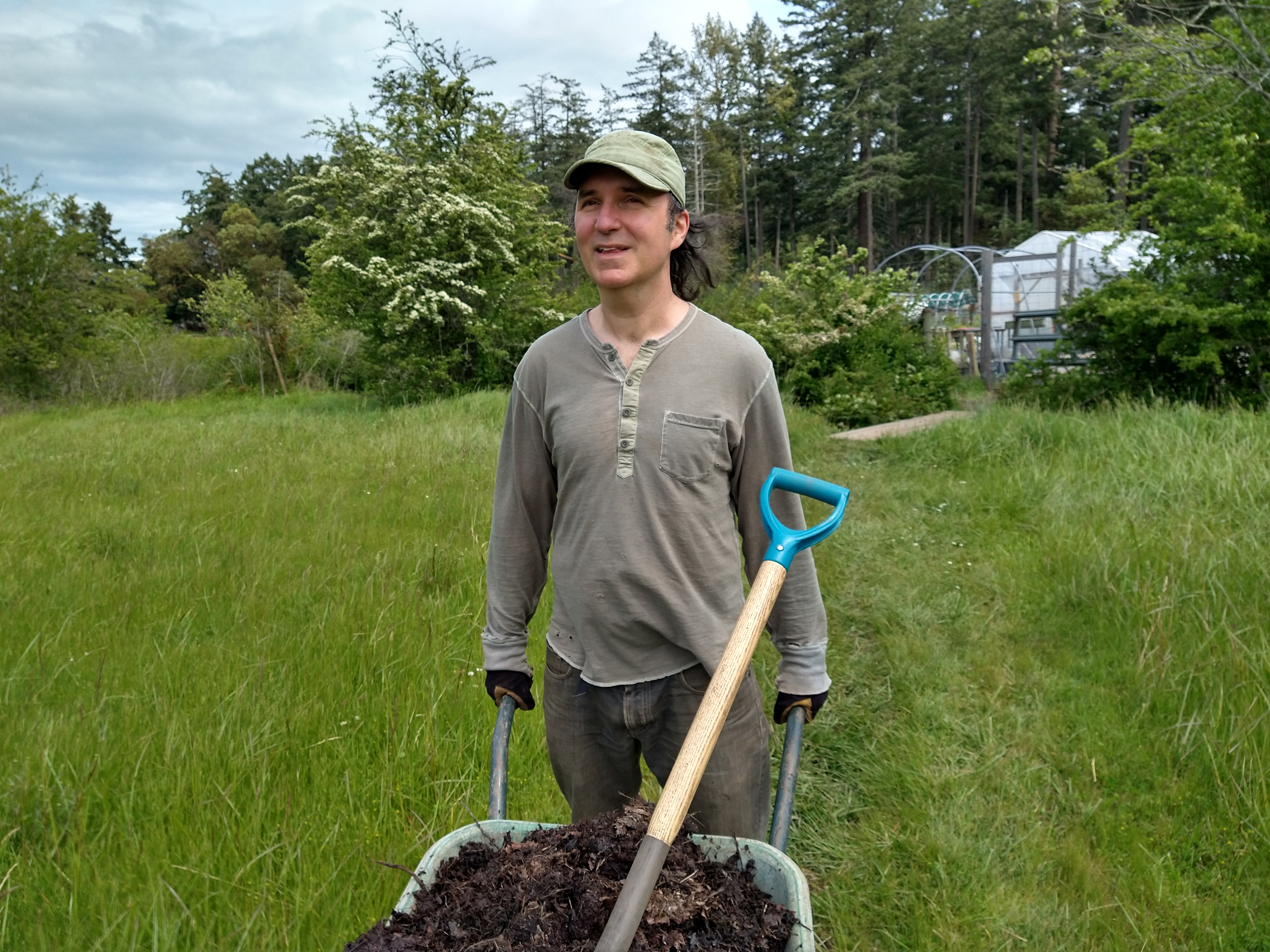 Photo of man pushing a wheelbarrow.